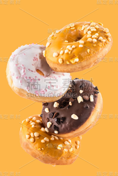 飞行甜甜圈或甜甜圈创意形象。落下的食物在白色的背景。食物在运动
