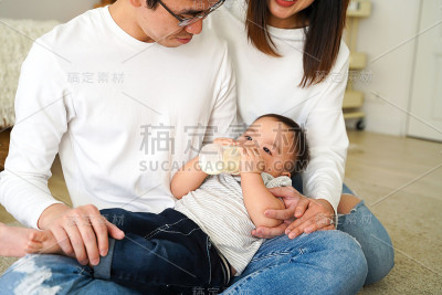 亚洲家庭，年轻的父亲和母亲用奶瓶喂一个男婴
