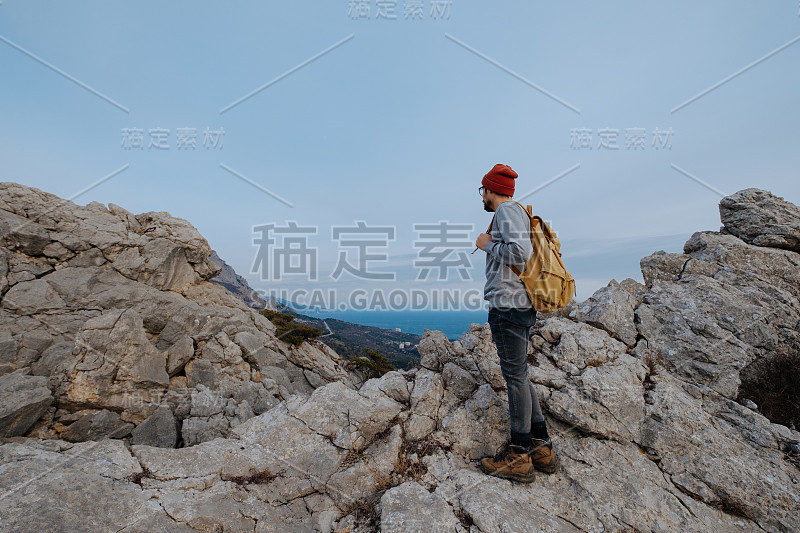 男人背包徒步旅行和红帽子在山区