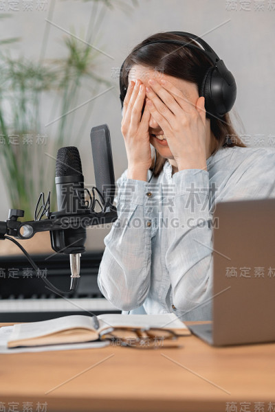 播客创建内容，欧洲妇女记录播客与麦克风和耳机，高加索妇女在录音工作室录制广告或有声书的声音