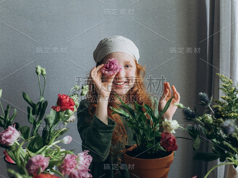 红头发的小女孩摆弄着家里的花