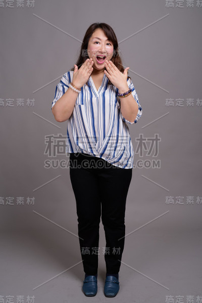 工作室拍摄的成熟美丽的亚洲女商人在灰色的背景