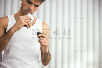 一个年轻人在家里用除臭剂
