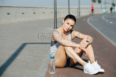 一个坐在户外跑道上休息的女运动员的肖像