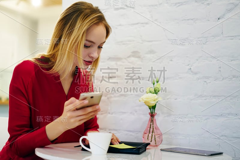 有魅力的女商人在工作间隙拨打银行服务电话，集中精力的年轻行政经理使用智能手机浏览项目信息