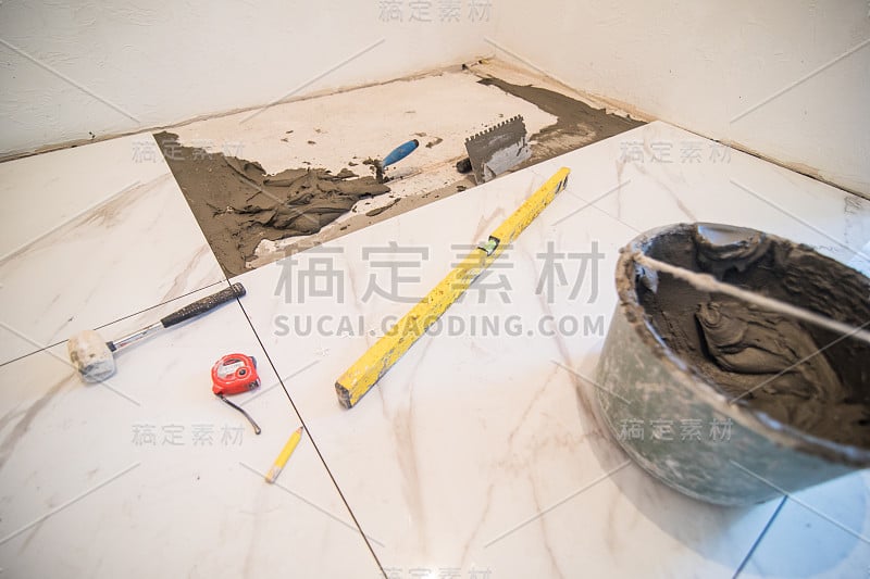 安装地砖。瓷砖和不同的家居工具