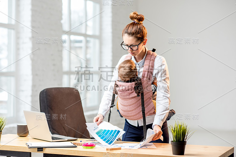 女商人带着她的儿子在办公室处理文件