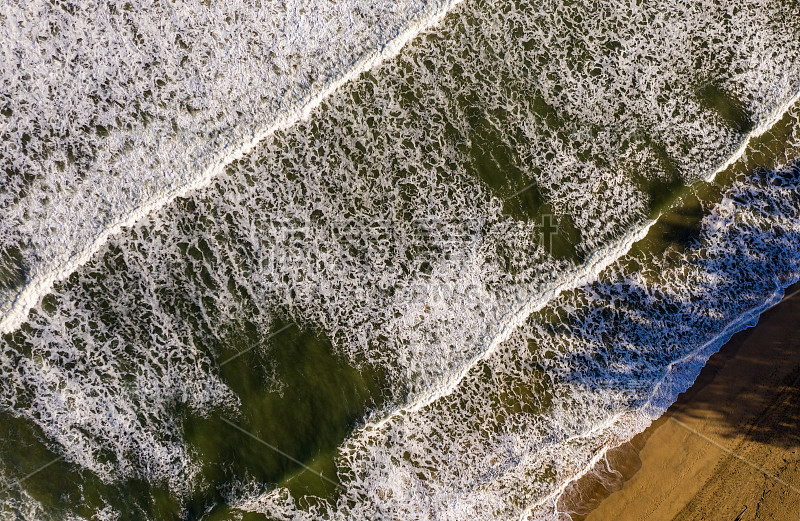 从上到下的垂直视图，海浪冲击着考艾岛的哈纳雷海滩