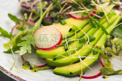 近距离观看新鲜的萝卜沙拉与绿色蔬菜和鳄梨