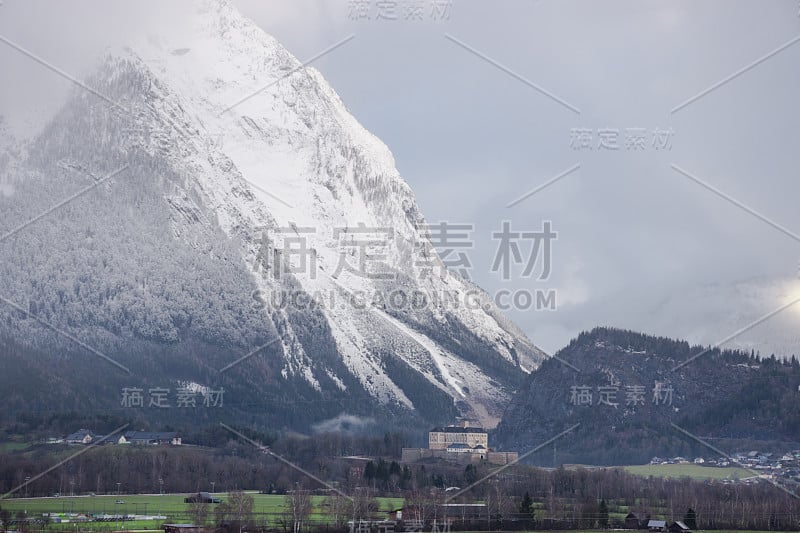 冬天的风景与白雪覆盖的格林明山和特劳滕费尔斯城堡在Liezen地区在斯蒂里亚，奥地利