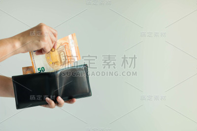 手从短钱包中挑选欧元钱在欧盟国家支付。