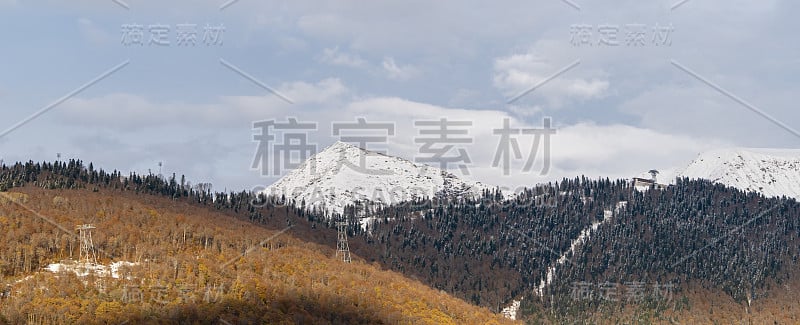 在红杉波利亚纳度假村的观景台上，高加索山脉的雪峰。山峰和秋天的森林在晴朗的日子，11月多云的天空背景