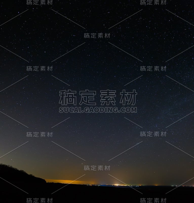 夜空中的星星和地平线上的城市灯光。