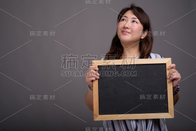 工作室拍摄的成熟美丽的亚洲女商人在灰色的背景