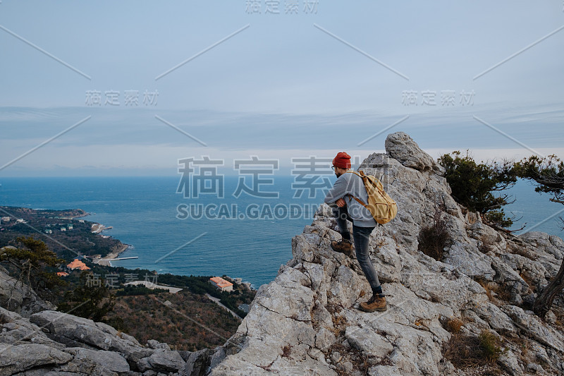 男人背包徒步旅行和红帽子在山区