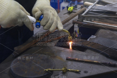 工人用乙炔炬切割金属。行业