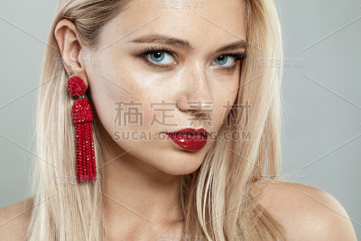 金发女人与红色耳环，美丽的脸近距离肖像