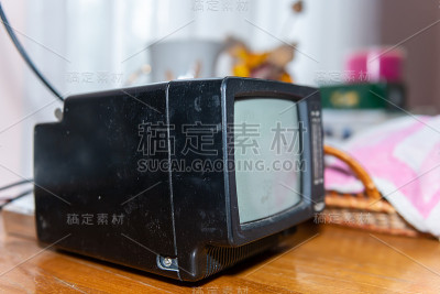 一个小的黑色电视的特写，复古的别墅在乡村乡村客厅的木桌上的家