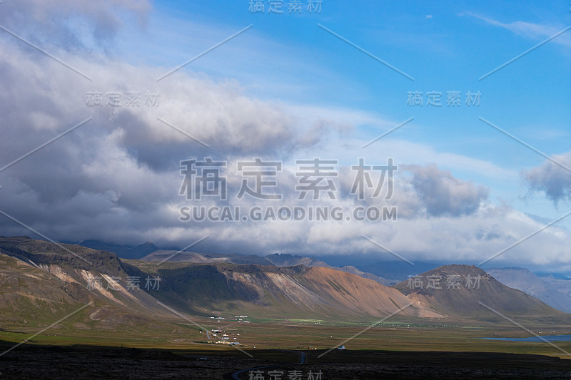 冰岛的风景与山，蓝天和绿色的草地在前景。西方峡湾部分