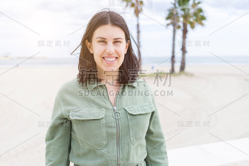 年轻漂亮的女人在海滩上笑得很开心