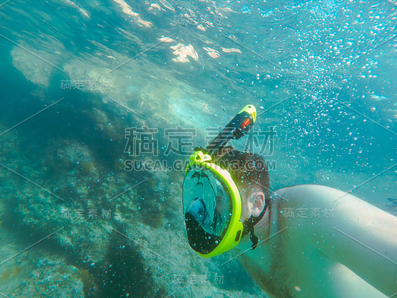 戴着浮潜面罩的男子在水下夏季海上度假