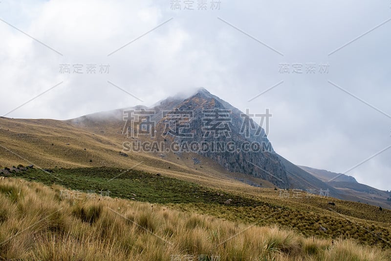 在墨西哥托卢卡不活跃的火山上，落基山脉的山峰对着多云的天空