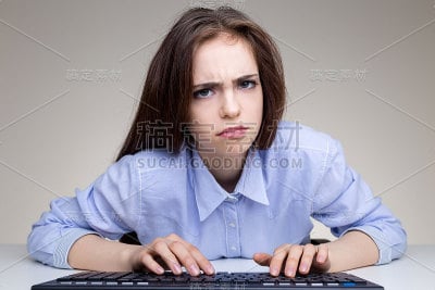 皱眉的女孩使用键盘