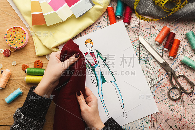 女时装设计师工作与面料样品和绘制的插图