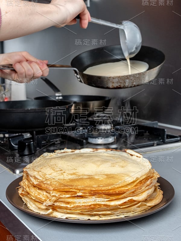 刚烤好的薄煎饼堆在热气腾腾的浅盘上。马斯伦尼察节日的传统美食。