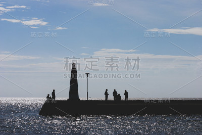 人们在秋天与灯塔在海上