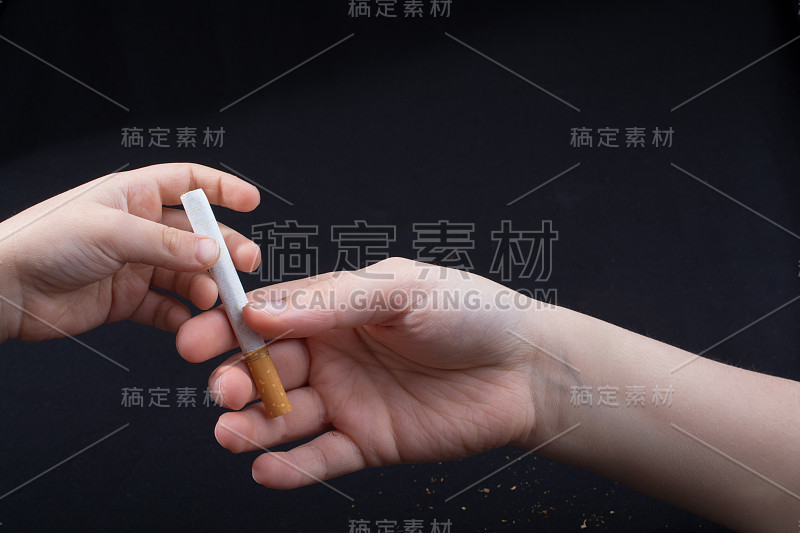 手在黑色的背景下分发香烟