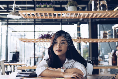 疲惫的女商人在办公室睡觉后醒来。疲惫的女人在工作场所打瞌睡。过度劳累、疲劳的概念
