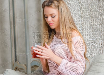 美丽的女孩在家里喝着热茶