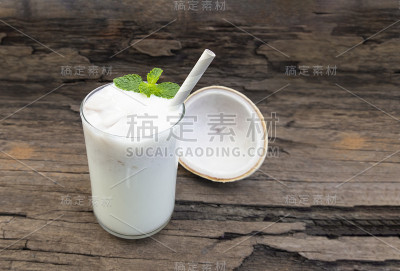 椰子冰沙白色果汁奶昔混合饮料健康高蛋白味道美味在玻璃饮料插曲早上在一个木制的背景。