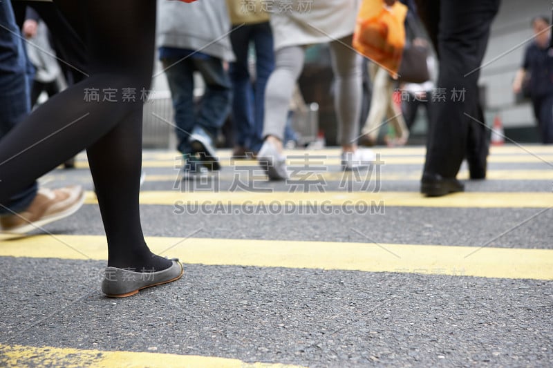 近距离拍摄穿越繁忙香港街道的通勤者的双脚