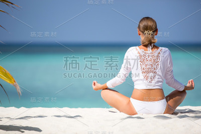 穿白色衣服的迷人女孩在海岸上沉思。马尔代夫