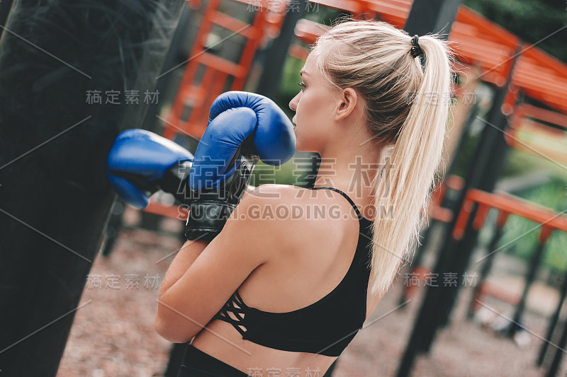 性感的金发女孩训练户外拳击