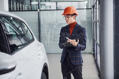 工人在保护头盔和记事本看现代汽车