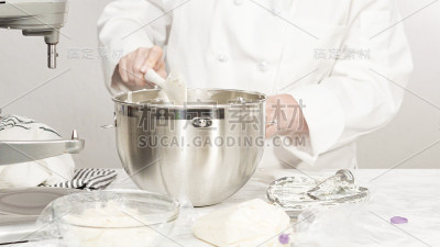 用立式厨房搅拌器搅拌原料，制作奶油糖霜。