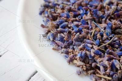 白色的盘子上放着薰衣草干花