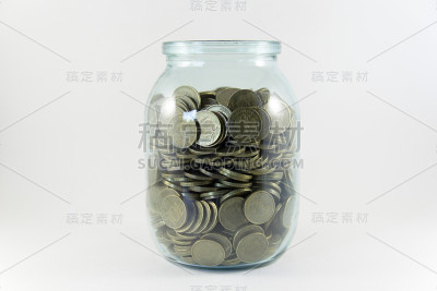 白色背景的玻璃罐里的钱