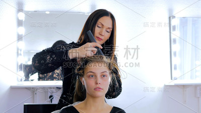 专业的美发师为年轻漂亮的女士做发型