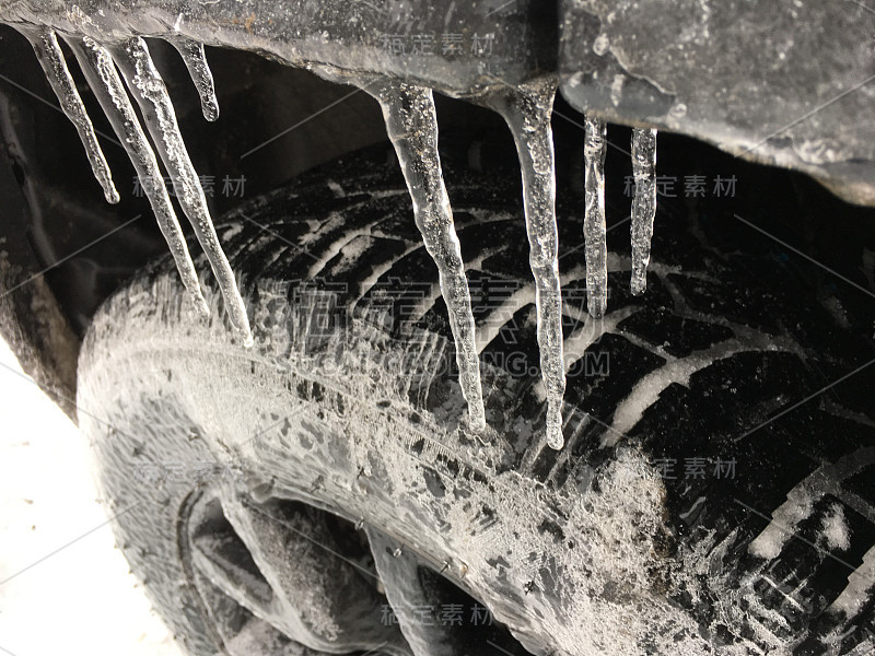 冰柱上的轮胎和汽车在冬季暴风雪和冰暴天气下危险驾驶