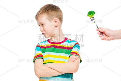 生气的男孩拒绝食用健康的花椰菜，肖像被孤立