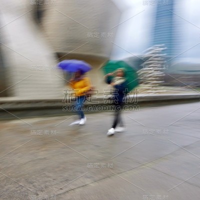 在西班牙毕尔巴鄂市，人们在雨天撑着雨伞行走