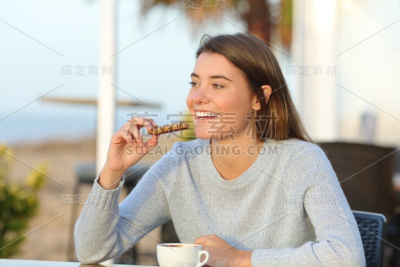 快乐的女孩在咖啡厅的露台上吃零食