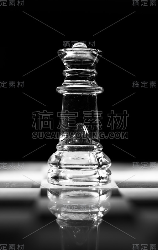 单玻璃皇后棋子或数字站在玻璃棋盘上。