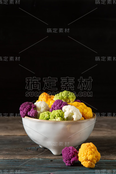 彩虹般的食物。紫花椰菜，橙花椰菜和西兰花，从当地市场在伦敦。素食主义者和素食主义者的食物。黑暗的背景