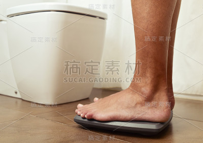 年轻人站在磅秤上