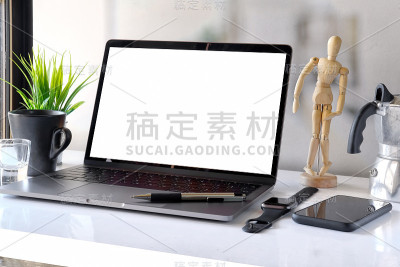 时尚的工作空间与模型的空白屏幕笔记本电脑，书籍，智能手机在桌子上